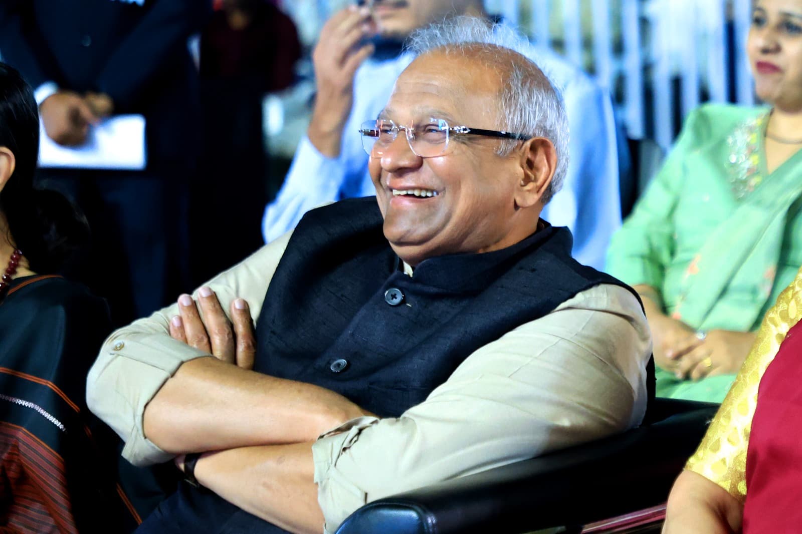 Bhupeshbhai seated with arms folded at a community gathering