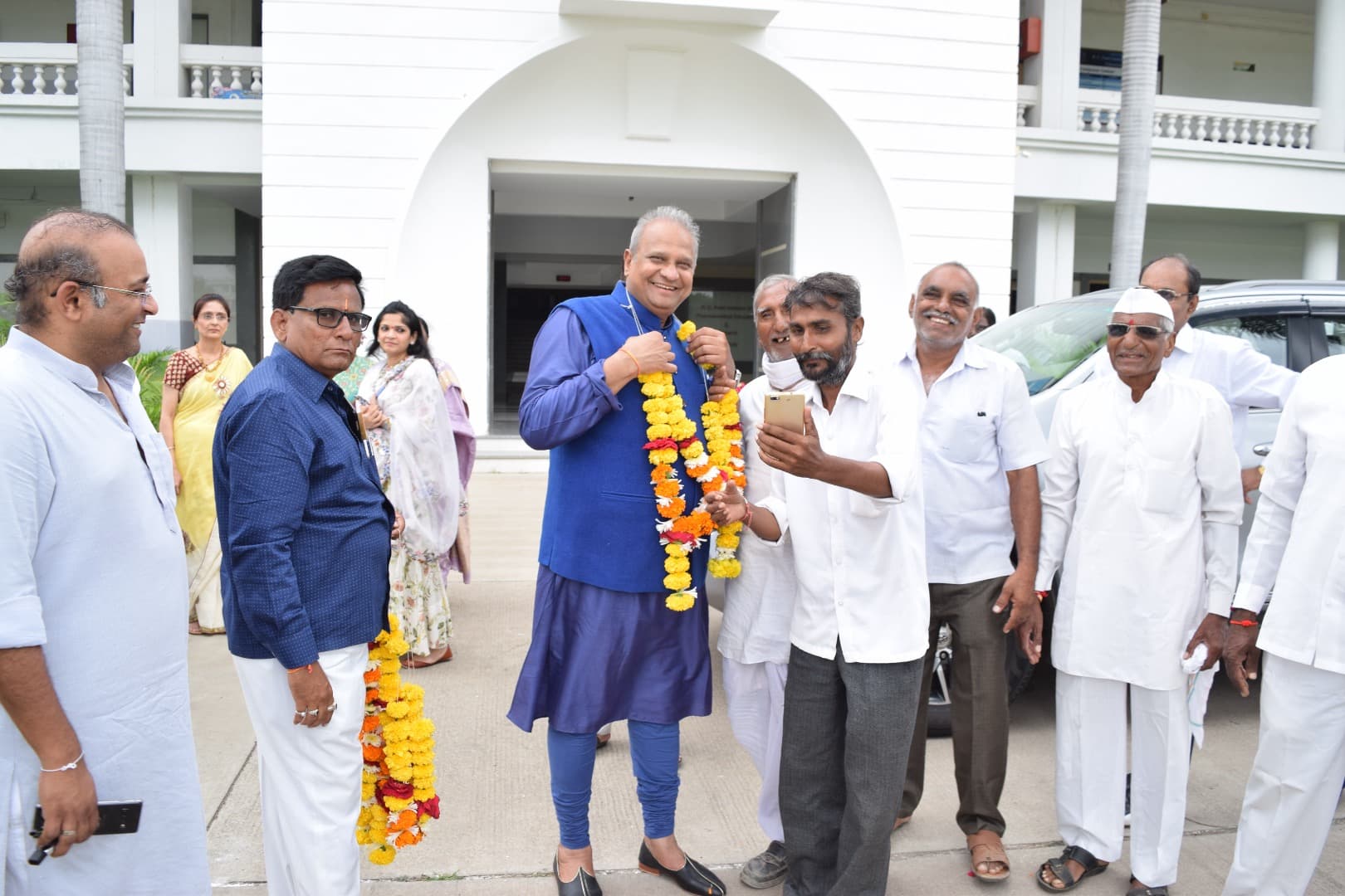Bhupeshbhai being garlanded by community members