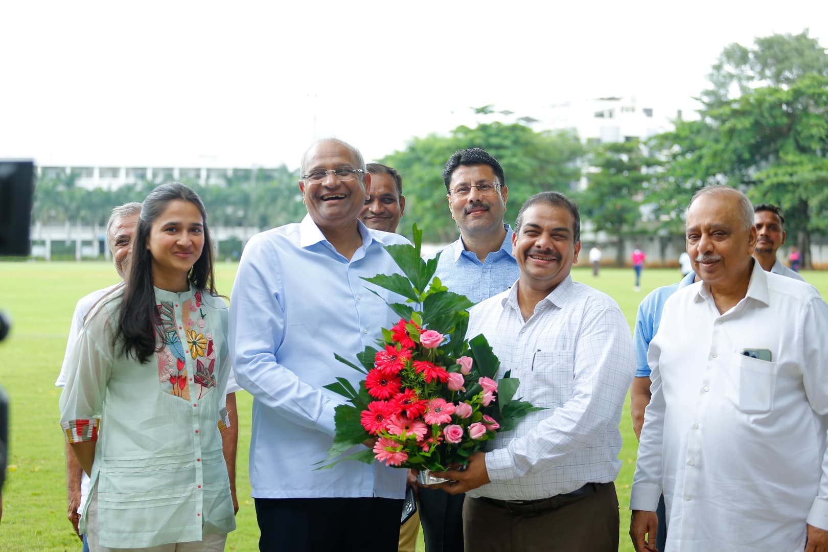 Bhupeshbhai with young people holding a bouquet
